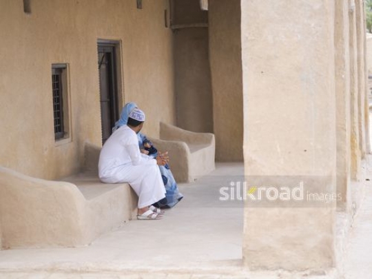 Couple sitting on bench outside|-