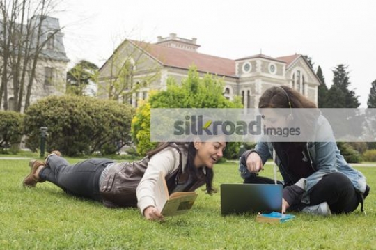 Woman with laptop showing the girl something |