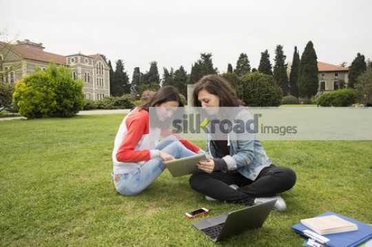Two friends sitting together on campus|
