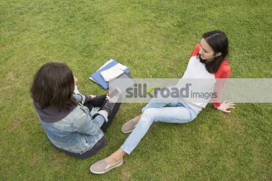 European woman sitting together on the grass|