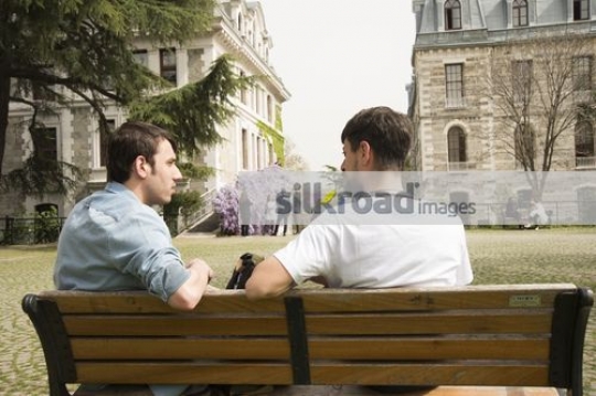 Men sitting on the bench together|