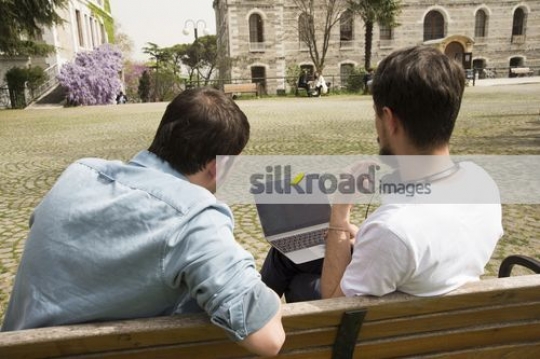 Men sitting together on the bench working