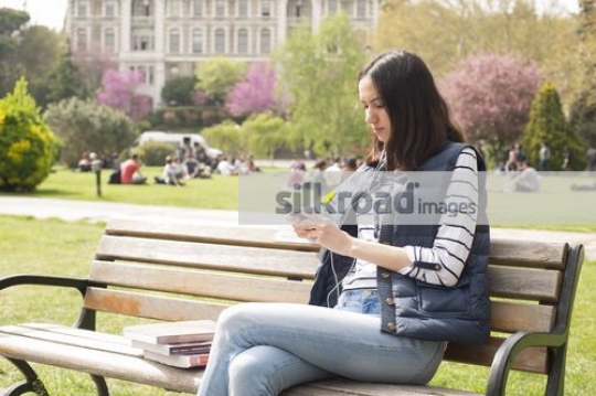 Woman sitting on the bench using her mobile|