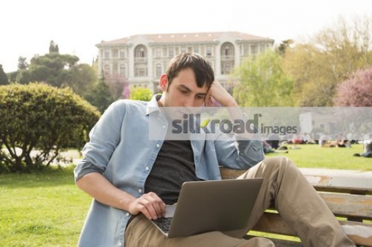 Man sitting on the bench using the laptop |