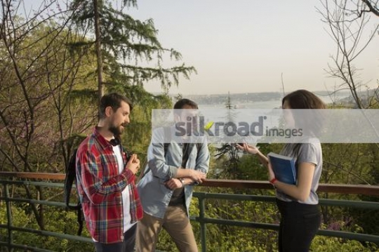 Group of three people talking to each other|