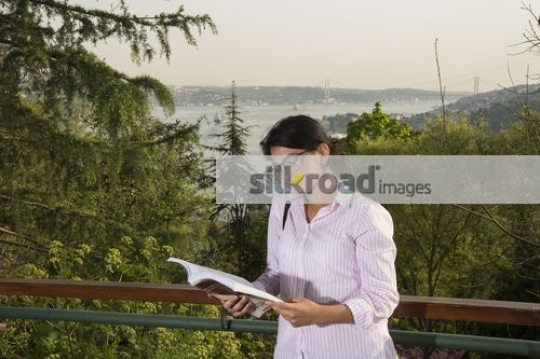 Woman standing reading a book|