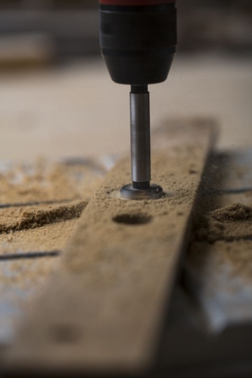 Machine drilling holes in the wood