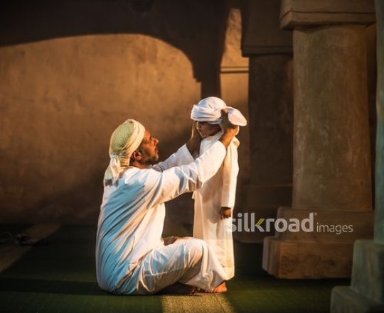Old man fixing outfit of grandson|-