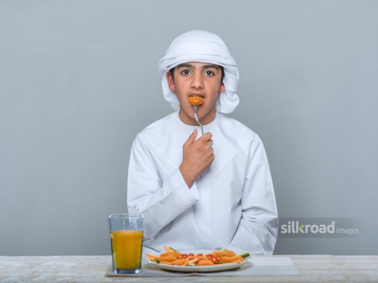 Little boy eating with a fork