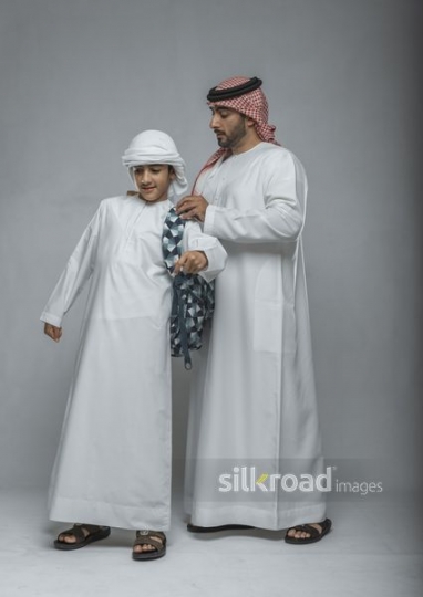 Arabian father helping his son with his school bag