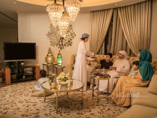 Boy serving brother Arabic sweets|-