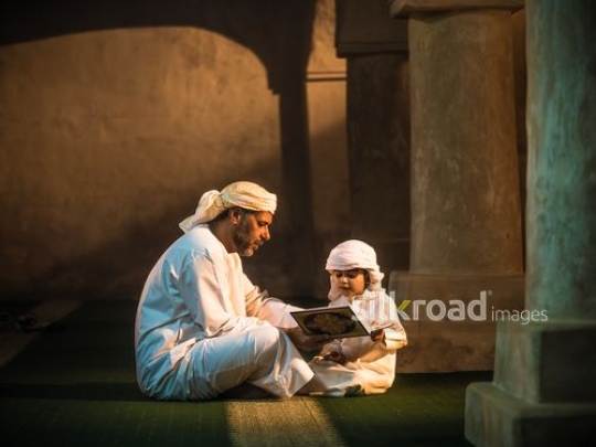 Kid reading qur'an with grandfather|-