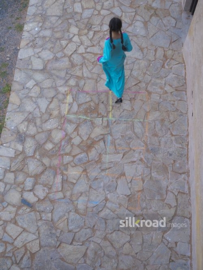 Girl jumping and playing hopscotch|-