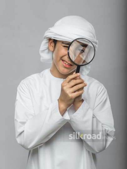 Little boy looking through his magnifying glass