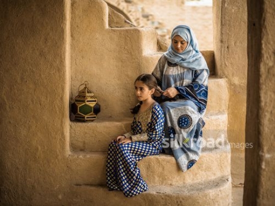 Mother fixing hair for daughter|-