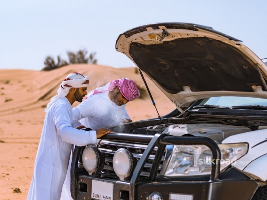 men peaking into car trunk