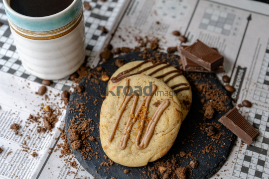 Cup of Coffee and Chocolate on Newspaper Games Page
