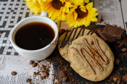 Cup of Coffee and Chocolate on Newspaper Games Page