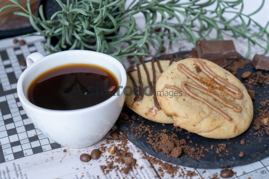 Cup of Coffee and Chocolate on Newspaper Games Page