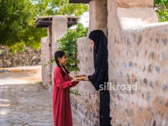 Little girl offering food to neighbour|-