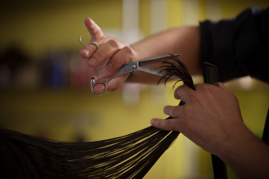 Hair stylist cutting the woman's hair|