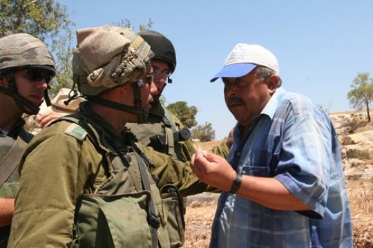 palestinian man talking with israeli soldier
