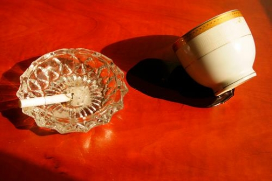 ashtray with lit cigarette on red