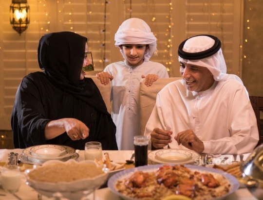 Grandparents with grandson having iftar|-