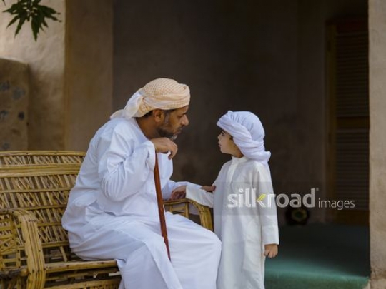 Grandfather talking to little boy|-
