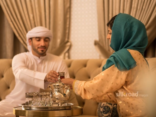 Wife serving husband tea|-