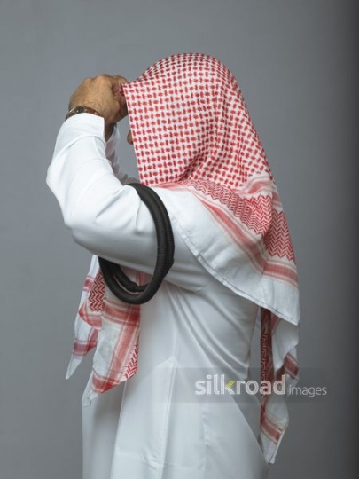 Arabian man fixing his traditional attire