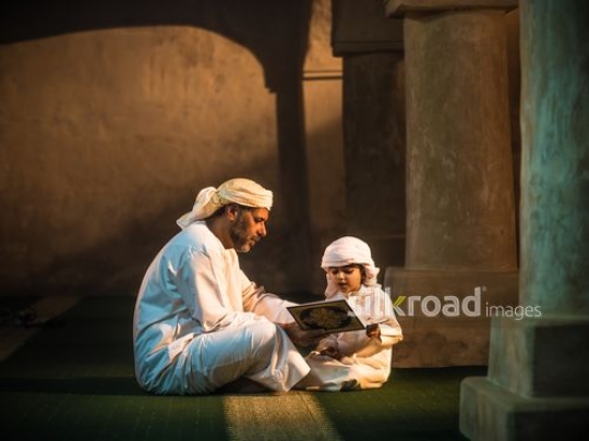 Grandson reading qur'an with grandfather|-