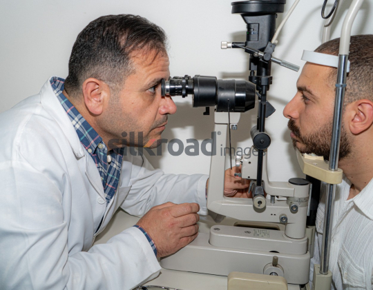 Doctor Examining Patient's Eyes with Ophthalmoscope for Eye Health