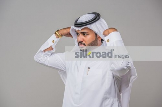 Middle Eastern Businessman fixing his kandura|