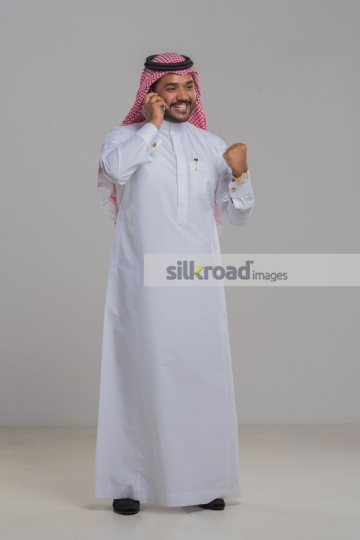 Middle Eastern man on the phone excited |