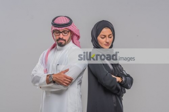 Middle Eastern Businessman and Business woman standing back to back|