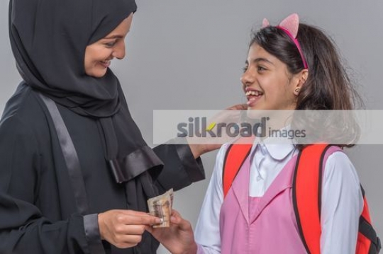 Middle Eastern mother giving the kid money