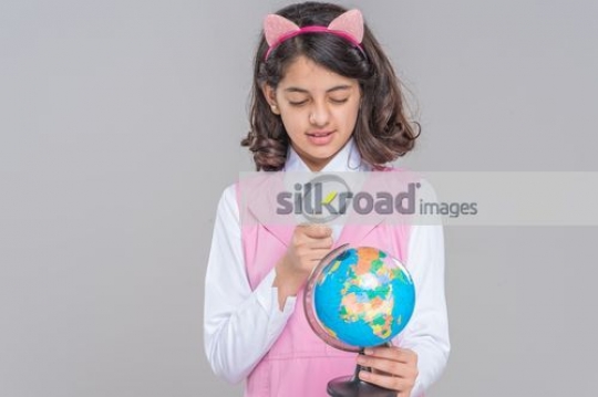 Looking at the globe through the magnifying glass|