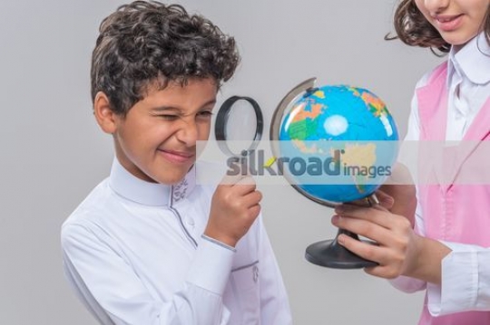 Middle Eastern kids looking at the globe |