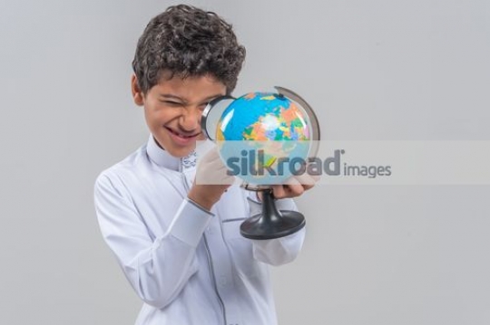 Young Arab kid looking at the globe|