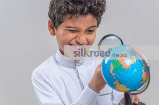 Middle Eastern kid looking at the globe|