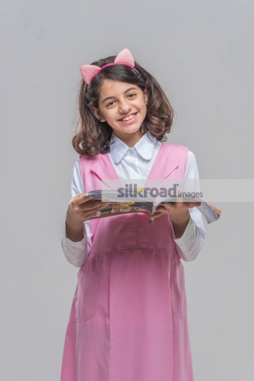 Young Middle Eastern girl reading a book|