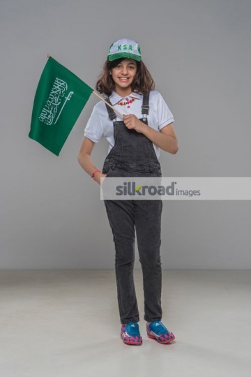 Arab kid carrying the KSA Flag|