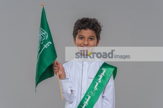 Arab kid carrying a Saudi Flag