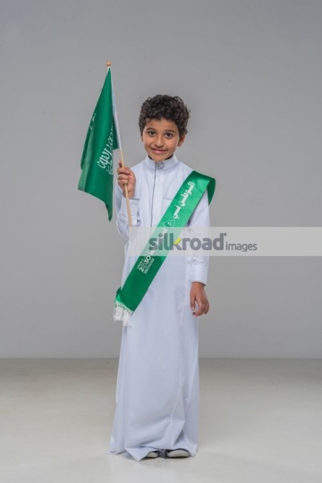Middle Eastern Kid carrying a KSA flag