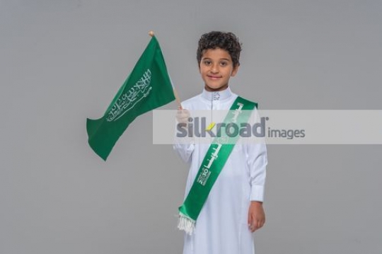 Arab kid carrying a Saudi Flag
