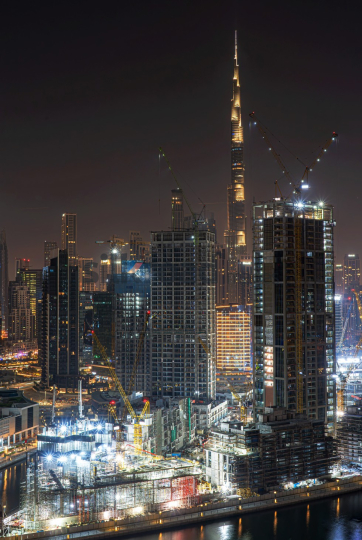 Dubai Skyline at Night with Burj Khalifa and Construction Cranes