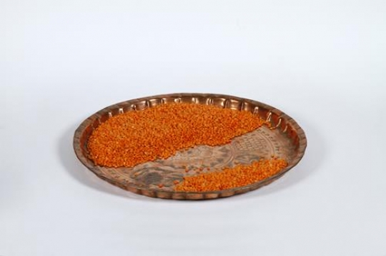 Yellow lentils in brass tray