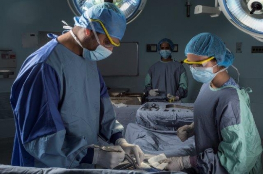 A Surgeon Holding a Suction at Operation Room