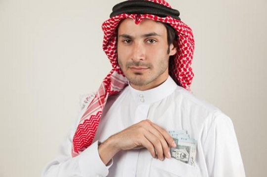 an arabian serious man take money from his pocket